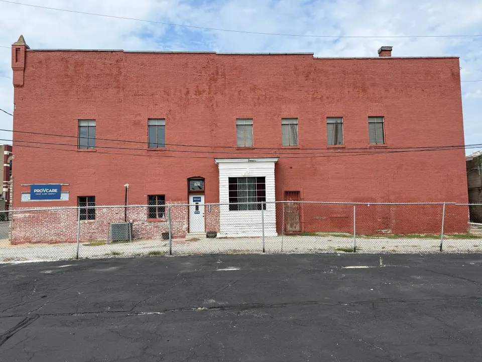 South side of Old City Hall with six upper windows, a projecting white bay and existing ground-floor doorways.