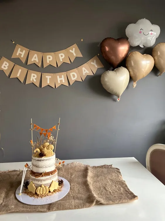 Birthday inspiration: a cake, gold balloons and a birthday banner. Stock photograph.